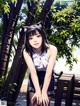 A girl in a school uniform sitting on a bench.