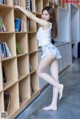 A woman standing in front of a bookshelf in a library.