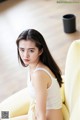 A woman sitting on top of a yellow chair.