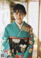 A woman in a kimono poses for a magazine cover.